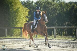 Cavalière souriante au galop sur un cheval alezan au centre équestre à Mont-de-Marsan L'Étrier.